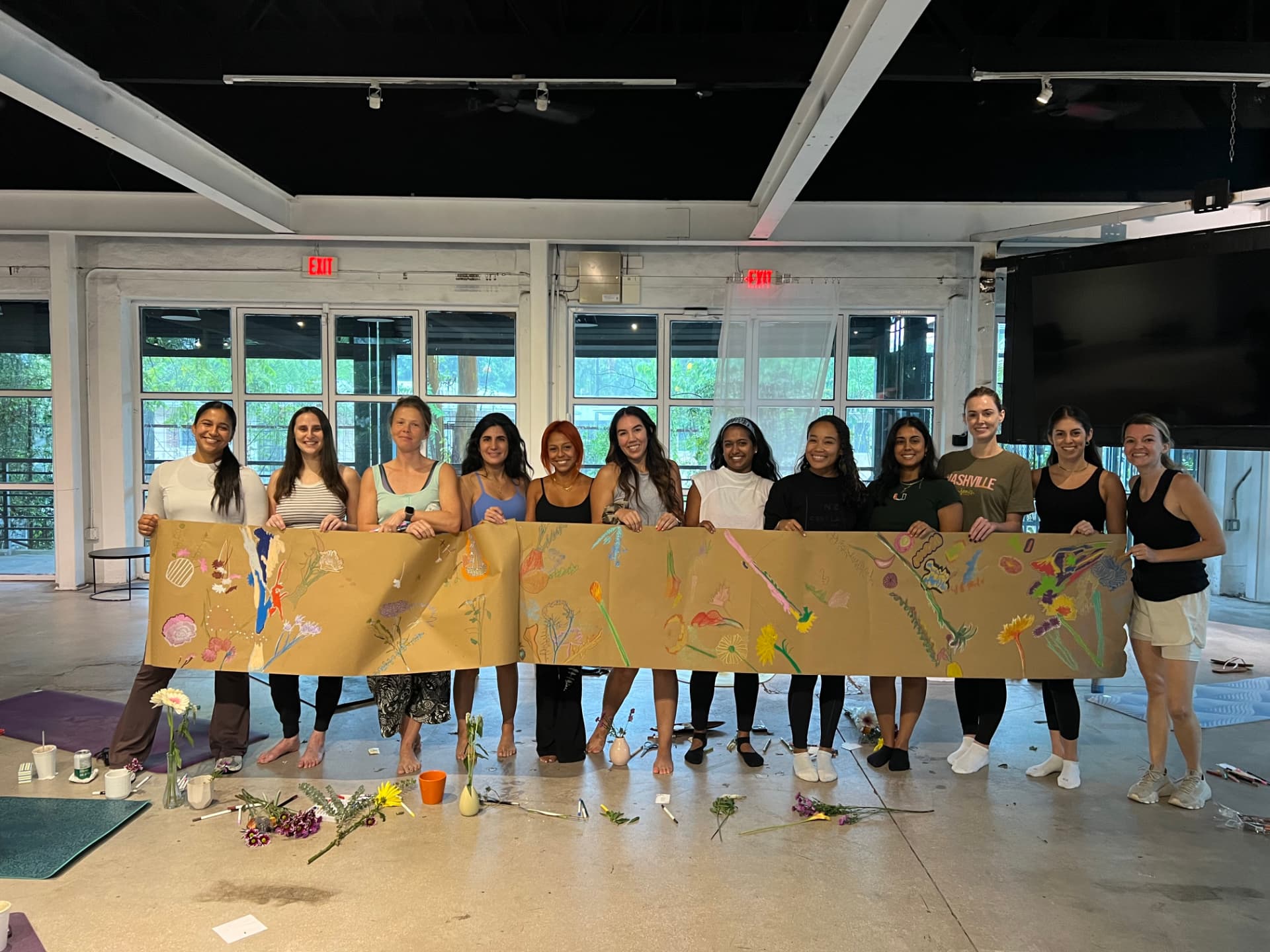 Group holding a hand-painted floral banner